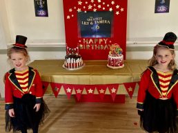 Two girls posing infront of their birthday cakes