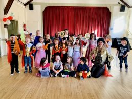 Children posing infront of red curtains