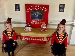 Two girls posing infront of their birthday cakes