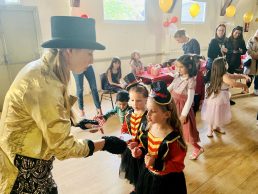Dancer in a top hat giving a prize to a girl