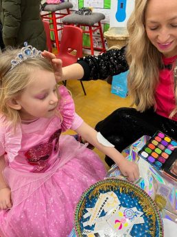 Dance party teacher doing a makeover on a girl in pink princess costume