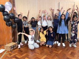 Group of girls posing with their arms up