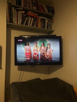 Shot of a television with four Bollywood dancers in pink costumes