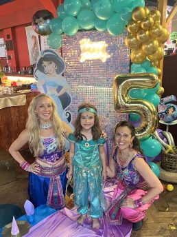 Two dancers dressed in Aladdin costumes with a birthday girl